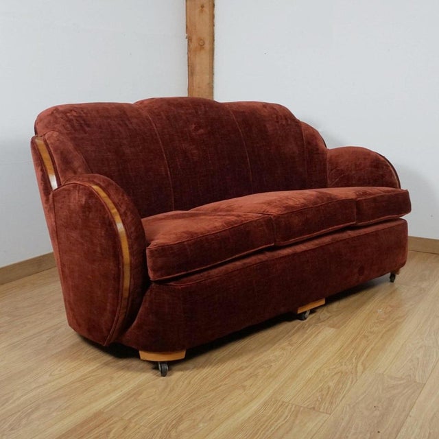 An art deco 'cloud' sofa by harry & lou epstein. Figured walnut banding. Re-upholstered in burgundy fabric. Dimensions: h...