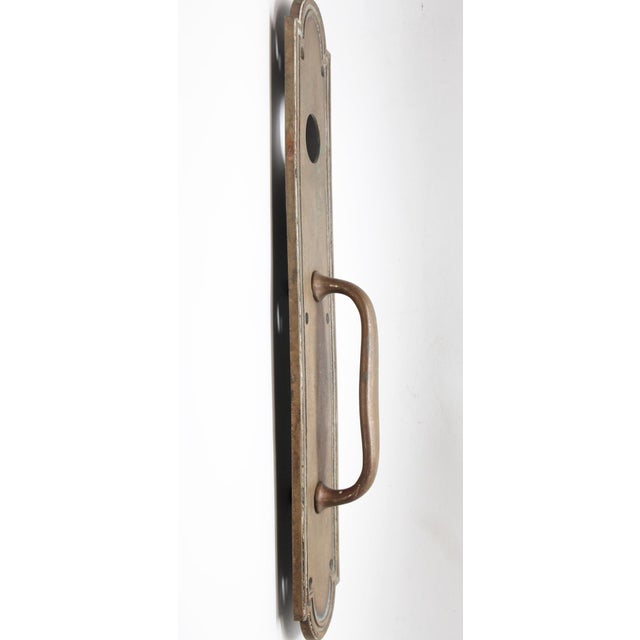 Bronze door pull with Art Deco lines and a lock insert. Inscribed 97490. The original mounting screws are not available....