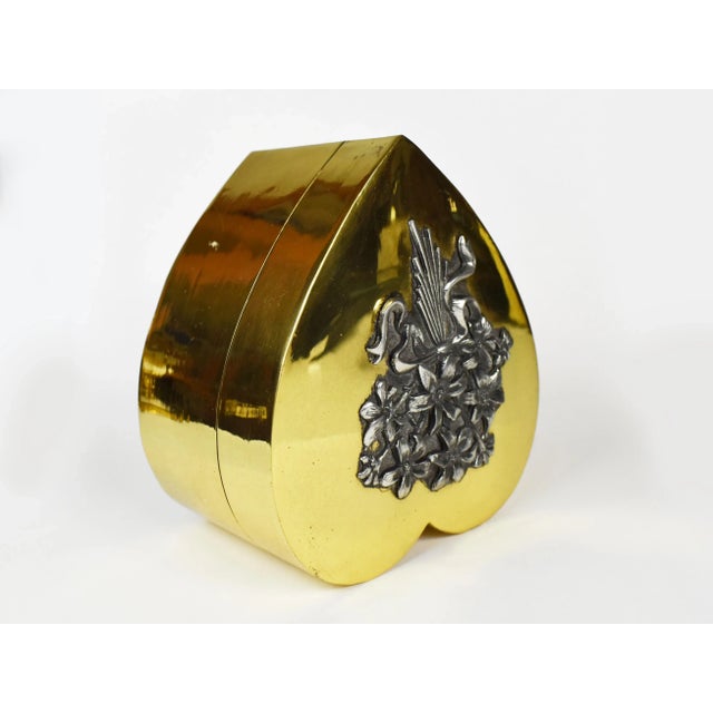 Stunning gold brass heart shape box embellished with flower bouquet. The Box is beautiful as a standalone piece on a...