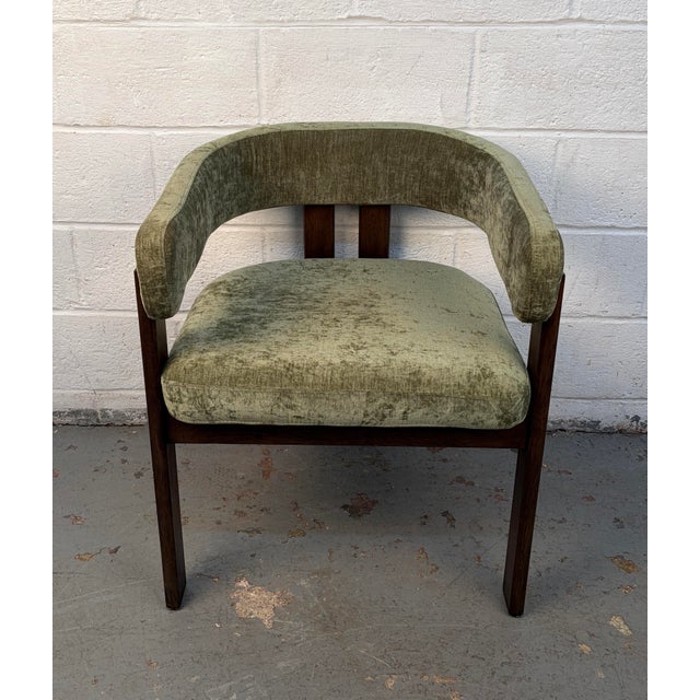 A mid-century modern chair crafted from rich walnut with comfortable green upholstery. Featuring clean lines and classic...
