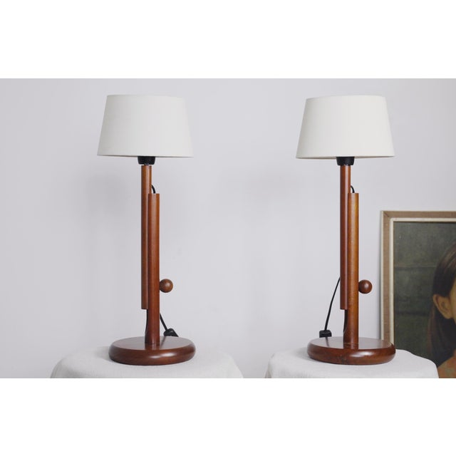 Vintage adjustable teak table lamps in the Scandinavian Mid-Century Modern style. Each lamp features a slim cylindrical...