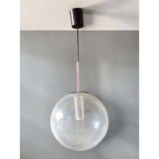 Beautiful vintage pendant light with an imposing globe of clear blown glass, riddled with numerous air bubbles trapped...