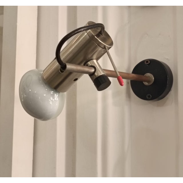 Chrome-plated brass wall lamp by Tito Agnoli for Oluce, with a structure composed of two adjustable arms in chrome-plated...