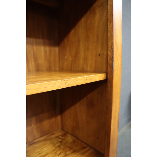 Ethan Allen cherry wood bookcase featuring a simple, rectangular design with four fixed shelves and an open front. The...