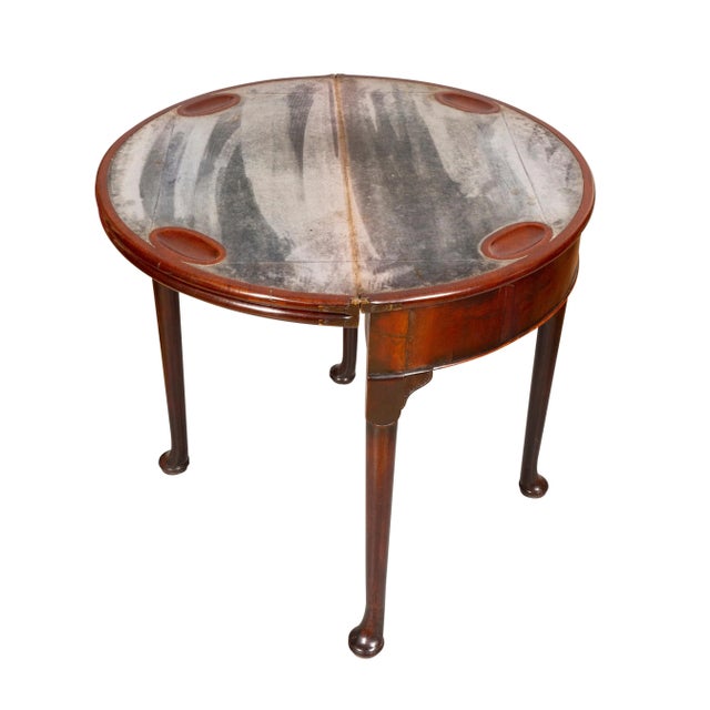 With triple top opening to a velvet playing surface. With interior well. Raised on circular tapered legs with carved...