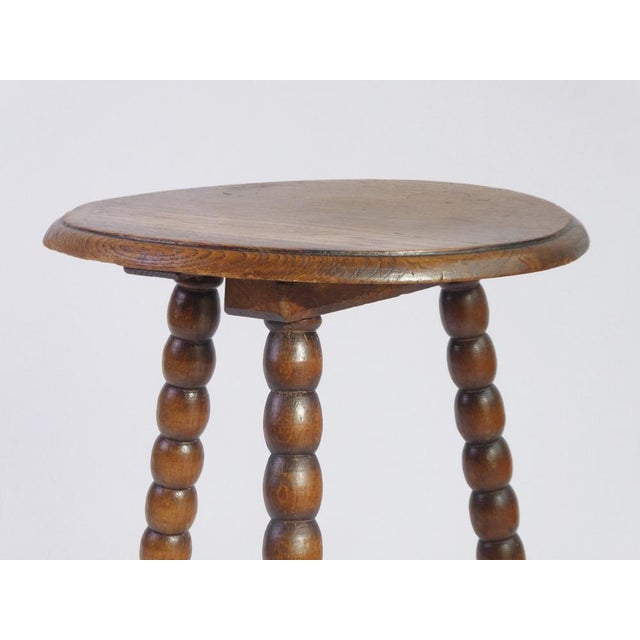 A small antique wooden side table with bobbin style legs made in France. The table has a a round top and is hand made. The...