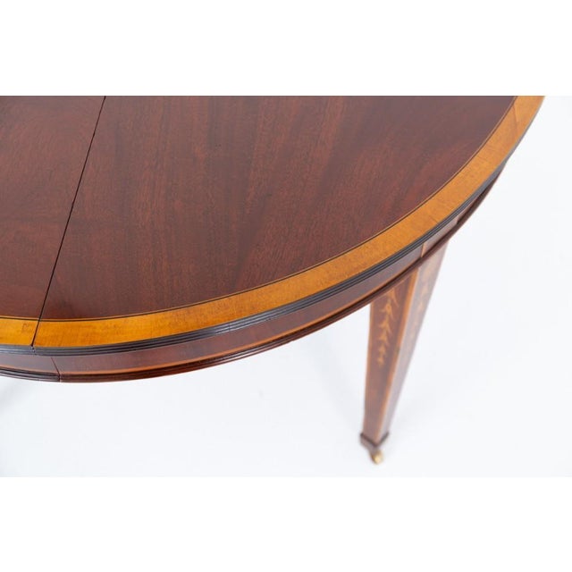A fine Sheraton Revival mahogany inlaid extending dining table, raised upon elegant tapered legs terminating in block feet...