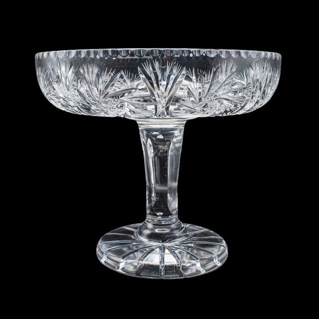 This is a vintage pedestal fruit bowl. An English, cut glass presentation display dish, dating to the mid 20th century,...