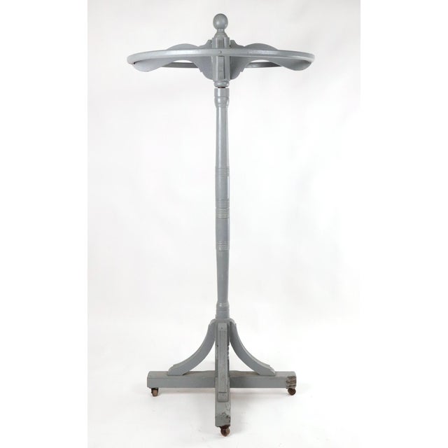 Late Victorian wooden rotating clothing rack painted gray. Turned central column, exposed joinery, and curved supports...