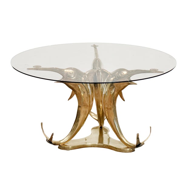 A fine French circular cocktail or coffee low table featuring a round glass top set upon a sculptural base of polished...