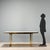 1980s table featuring a brass base that adds a touch of brilliance to the overall design. The light laminate rectangular...