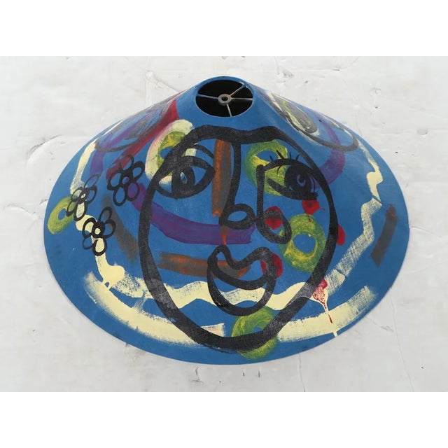 Vintage Peter Robert Keil painted lampshade featuring a blue background with an array of colors and a simple face....