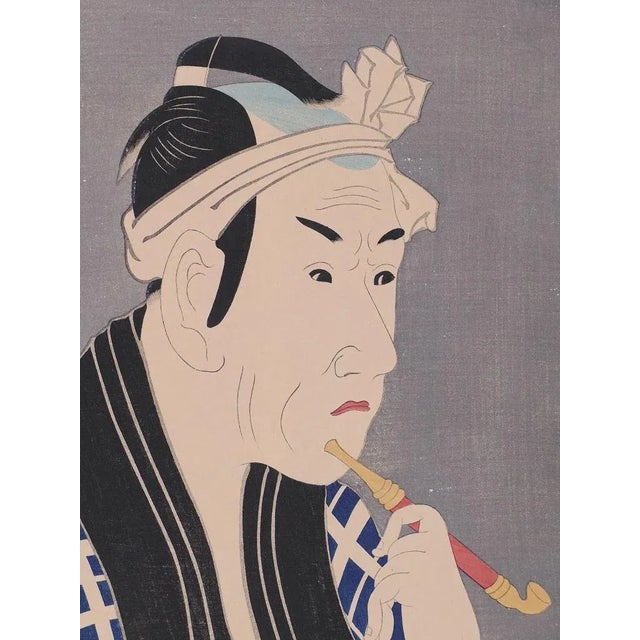 Portrait of Man with Pipe is a superb color woodblock print on paper, from the Japanese print-series “Taiheiki eiyu den”,...