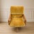 This vintage mid-century modern swivel-tilt armchair features textured mustard yellow upholstery and a wooden base with...