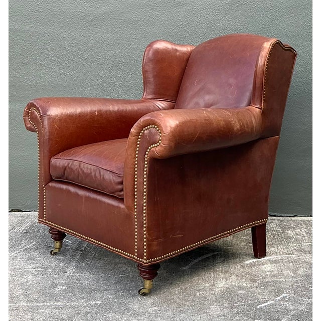 This exquisite leather wingback club chair and matching ottoman set, crafted by Milling Road for Baker Furniture,...