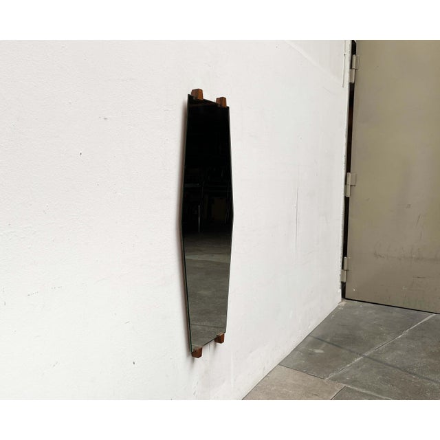 Mid-century wall mirror with a distinctive shape. The striking detail of this design lies in the unique shape of the...