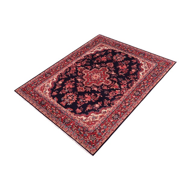 beautiful hand-knotted wool rug measuring approximately 7.1 x 9.10 feet. This elegant carpet features a deep navy blue...