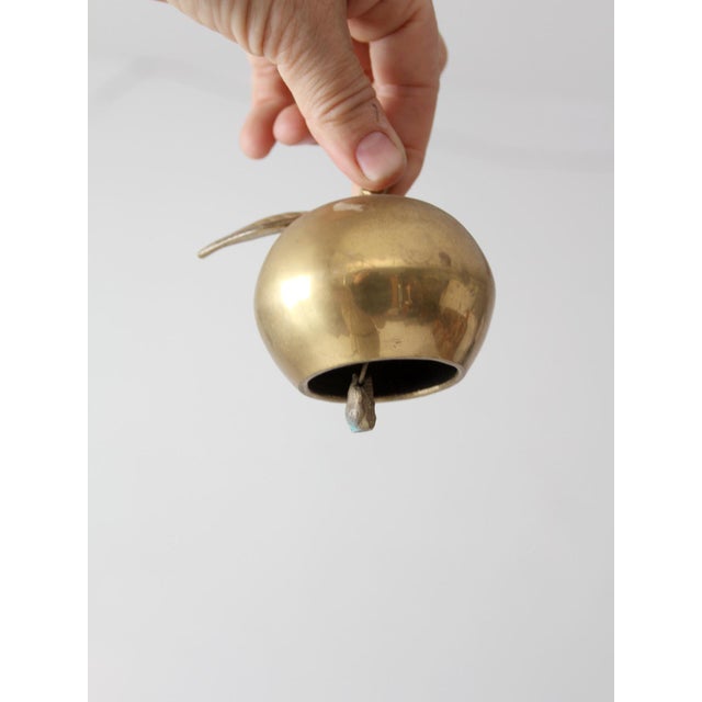 A charming vintage mid-century brass bell cast in the form of an apple, with a softly aged finish and finely articulated...
