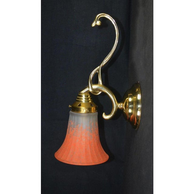 A striking mid-century wall light dating to the 1950s, combining a substantial solid brass structure with a beautifully...