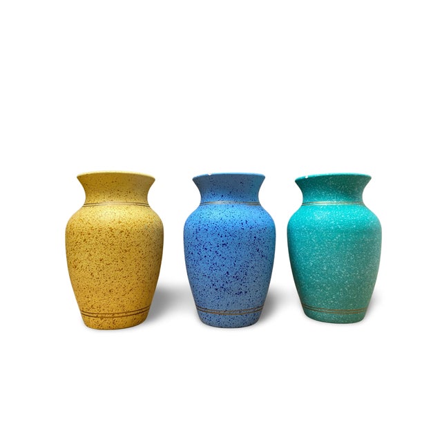 Set of three wheel-thrown ceramic vases, baluster-shaped with flared necks, resting on a ring base. Each piece is covered...