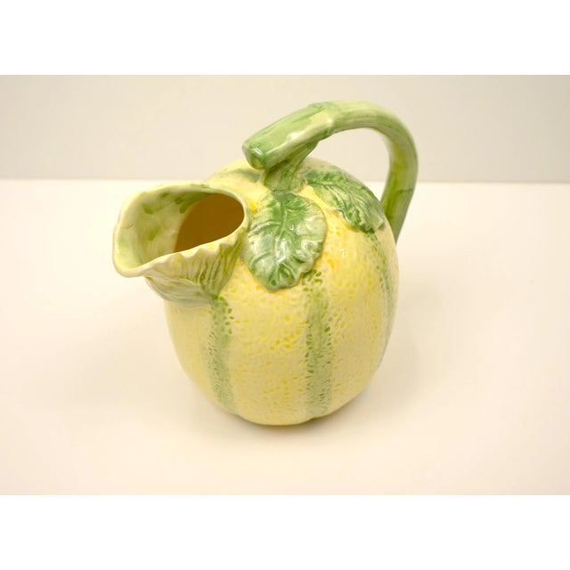 A vintage Majolica style ceramic pitcher in the shape of a cantaloupe melon. No maker's mark on the bottom. Hand wash only.