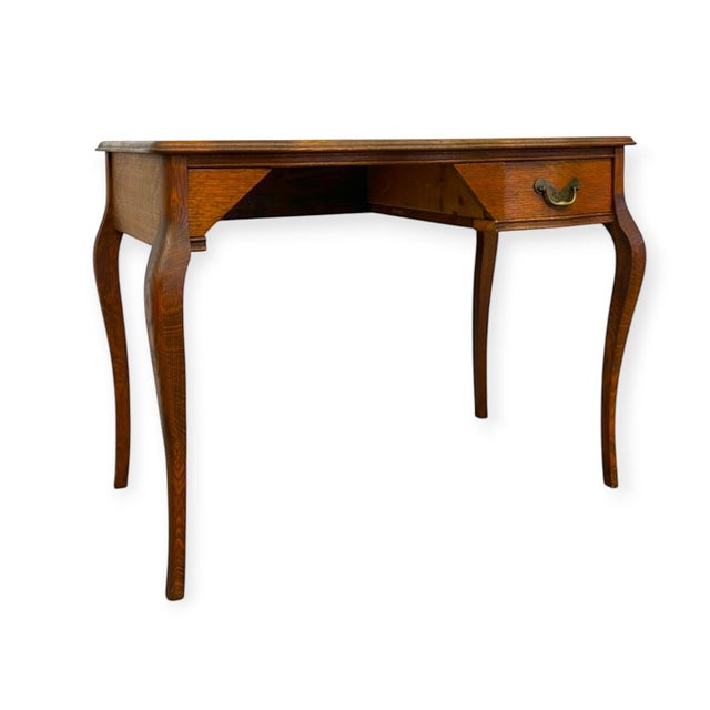 Crafted from quarter-sawn oak showcasing prominent tiger grain figuring, this antique writing desk features elegant...