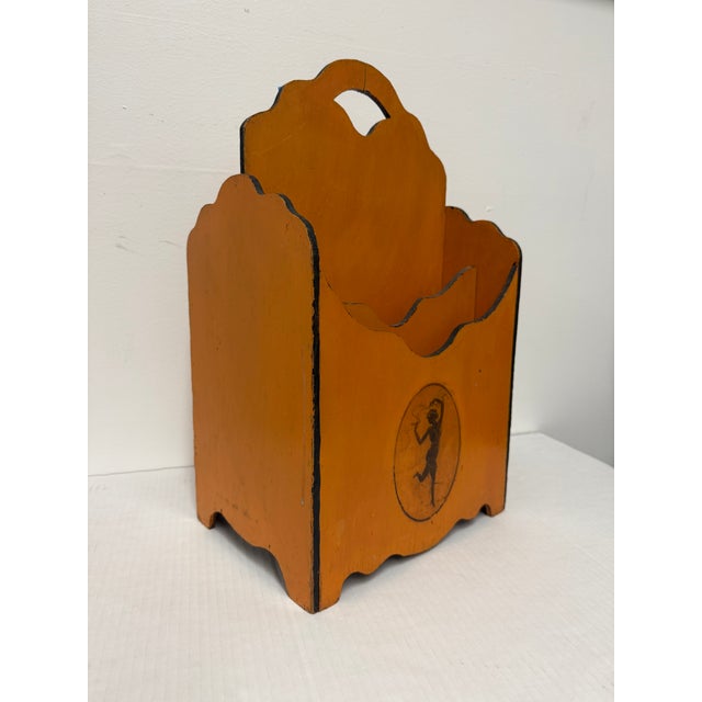 This vintage magazine rack features a charming design that combines functionality with artistic flair, showcasing a warm...