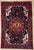 Antique hand-knotted rug from the Nahavand region of western Iran, featuring a bold central diamond medallion set within a...