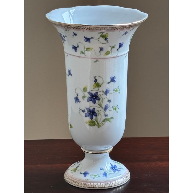 Graceful and refined, this vintage porcelain trumpet vase features delicate blue bellflowers and trailing botanical vines...