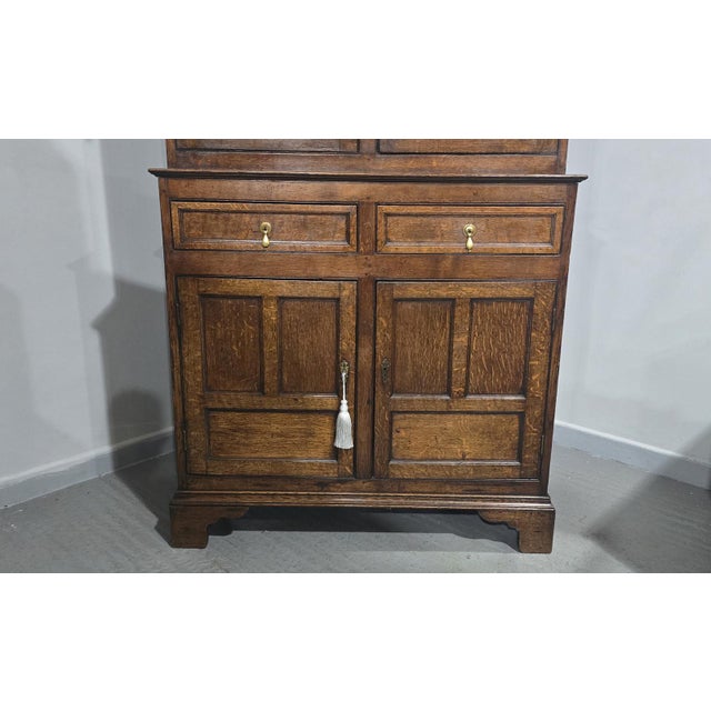 A very nice two piece Georgian oak court cupboard with panelled sides and doors, two drawers and four doors, standing on...