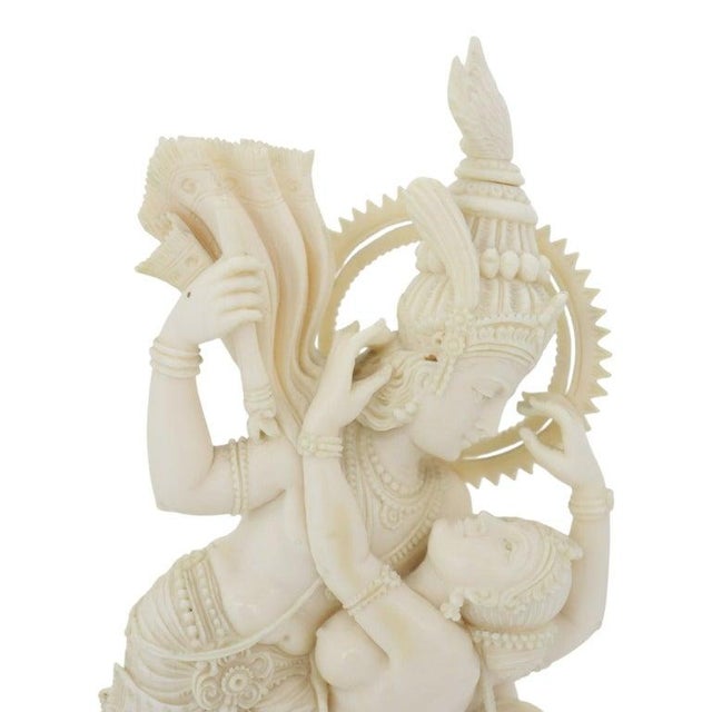 An antique Indian carved bone sculpture depicting the Hindu deities Radha and Krishna in a loving embrace. This finely...
