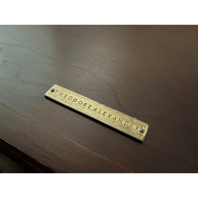 Stunning display table by Theodore Alexander. Hinged top with thick beveled glass framed by flamed mahogany with a brass...