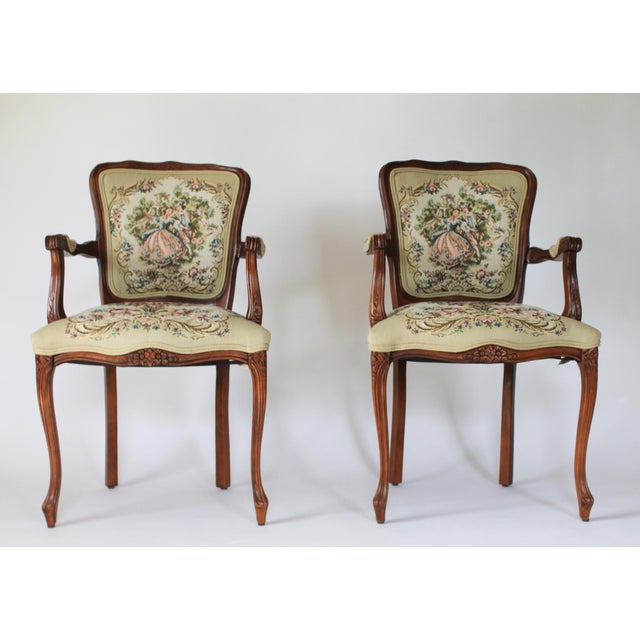 Pair of vintage French Louis XV style armchairs with needlepoint seat, backrests and arms. Backrest features a romantic...