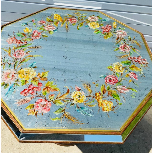 This is an Italian reverse painted mirrored side table. This table has a hand carved baroque style base with a floral...