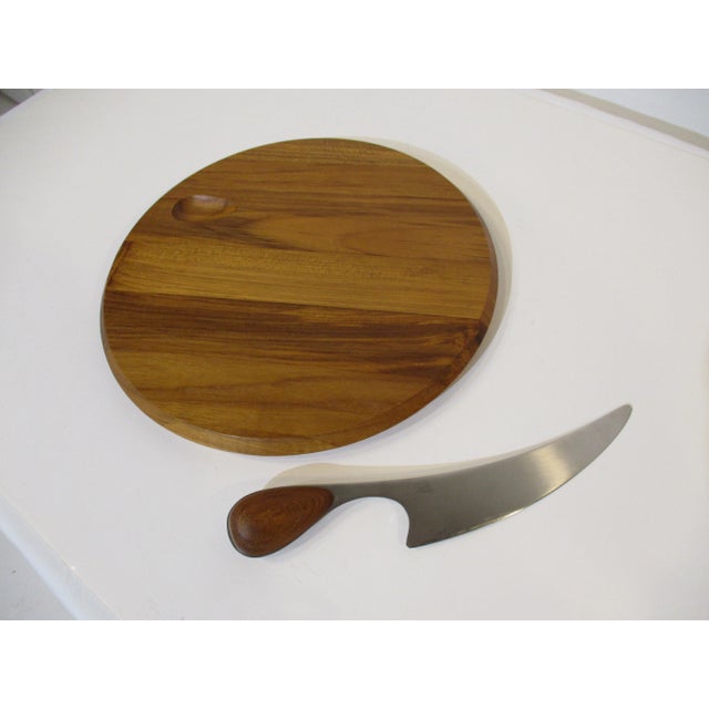 A two piece teak charcuterie board with matching teak handled stainless steel knife designed by Vivianna Torun for Dansk...