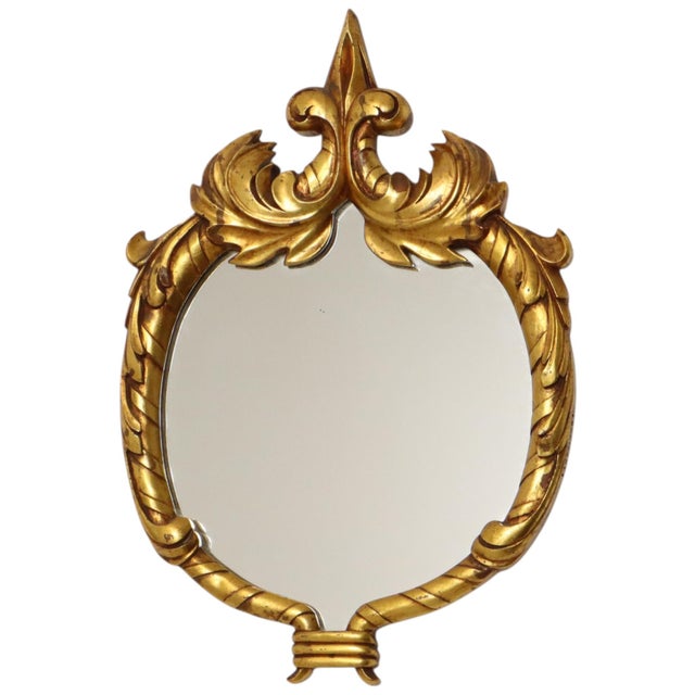 A beautiful, classic Baroque-style mirror gilded with gold leaf; the ornate frame is crafted from resin and marked...