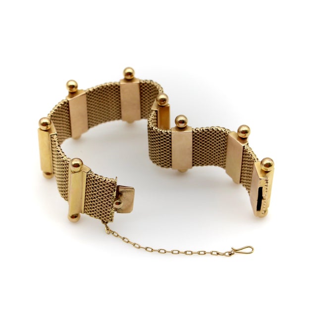 This 18k gold bracelet is composed of hand-woven gold panels, separated by triangular bars that are accentuated at the top...