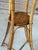 A charming pair of vintage faux bamboo plant stands featuring woven rattan tops and elegantly tapered tripod bases. The...