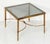 A French cocktail or low table with Modern styling, featuring a square smoked glass top set upon a brass frame of tapered,...