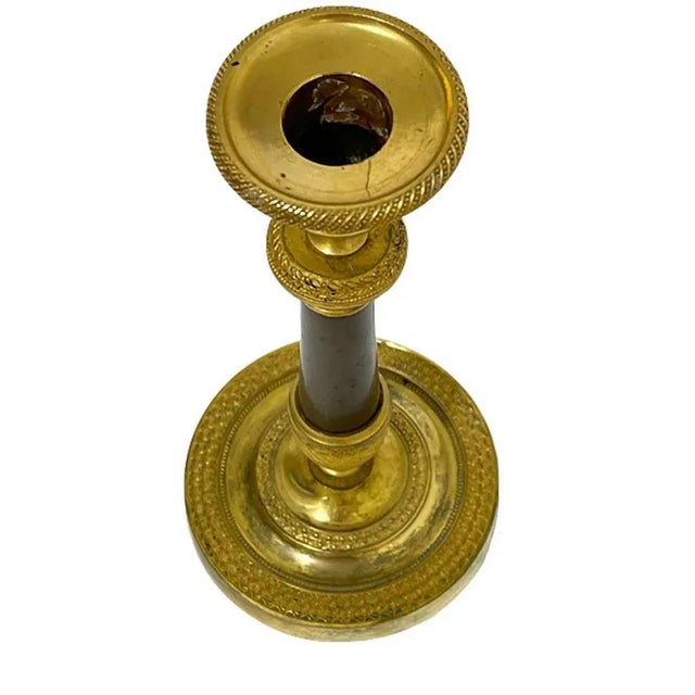 An 19th century French candlestick An bronze with gilt candlestick The candlestick measures 21 cm high and the foot 10 cm...