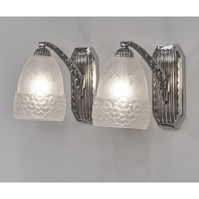 Hettier & Vincent A pair of French art deco wall sconces in nickel plated bronze and clear frosted molded-pressed glass....