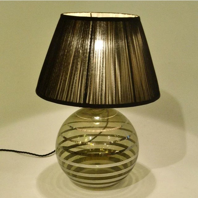Smoked handblown table lamp base with platinum cascading rings surrounding the globe. The shade is handmade in sheer black...
