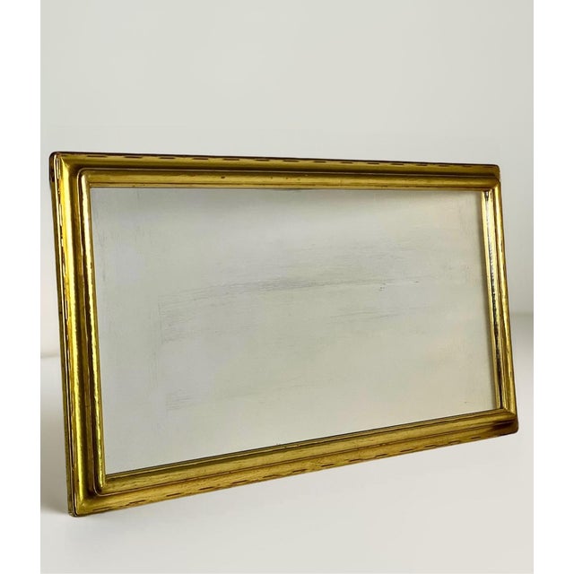 Timeless and elegant rectangular Hollywood Regency giltwood mantle mirror, circa 1940s. It displays a classic design with...