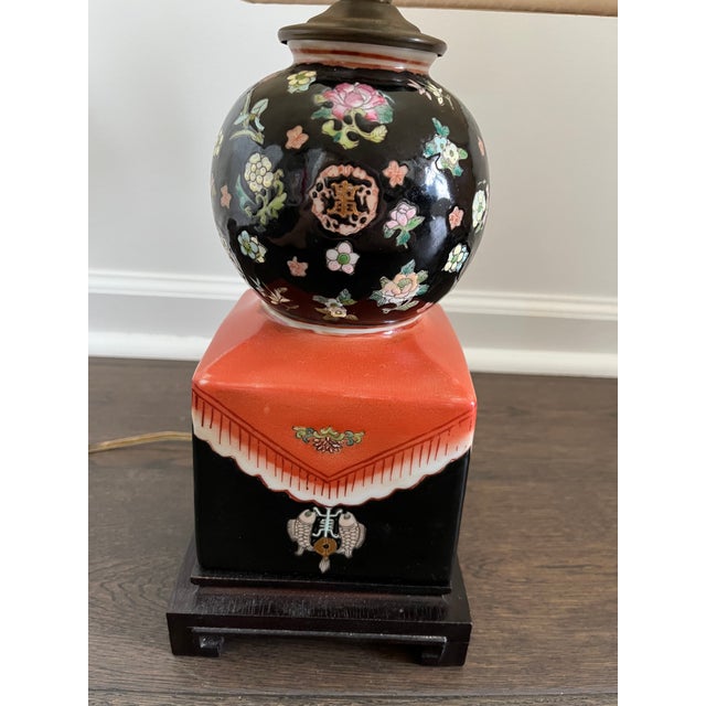 A vintage Maitland-Smith porcelain lamp featuring a richly contrasted black and pink base adorned with finely hand-painted...