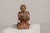 A Thai religious hand carved wooden statue of a seated Buddhist monk with polychrome and gilded accents from the early...