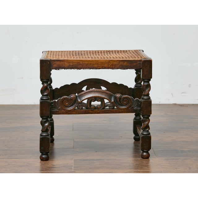 This English bench from circa 1900 offers a charming blend of utility and decorative detailing, suitable for both period-...