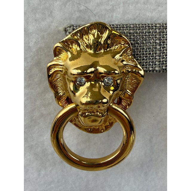 Gold tone lion head pierced earrings with rhinestone eyes by Kenneth Jay Lane. A fierce Eighties comeback made in 1986....