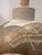 A vintage ceramic lamp base featuring intricate geometric carvings and a warm metallic‑bronze glaze contrasted with a...