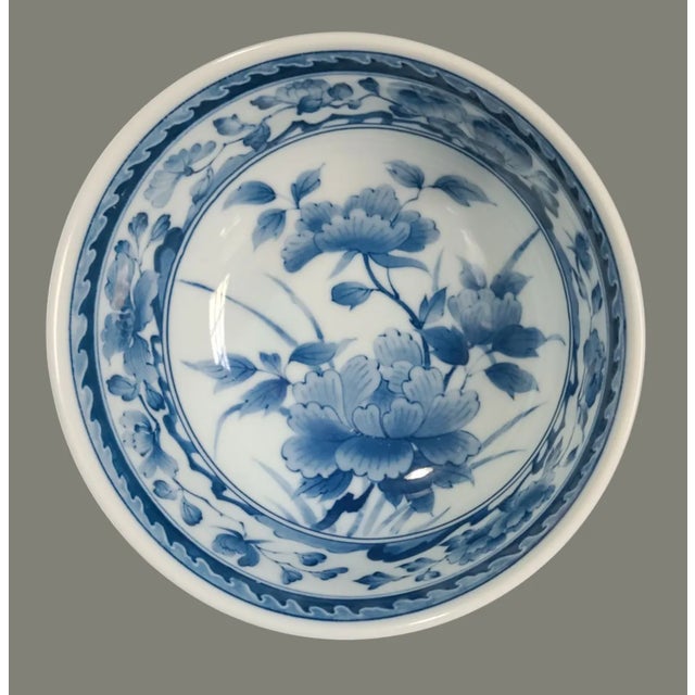 Discover the charm of traditional Japanese craftsmanship with this vintage pair of blue and white porcelain floral serving...