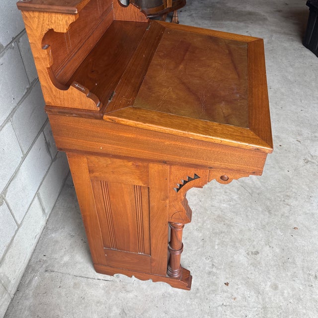 Solid oak Davenport slant top desk. Sawtooth carvings, compass points, turned legs, hand carved accents. Solid brass key...